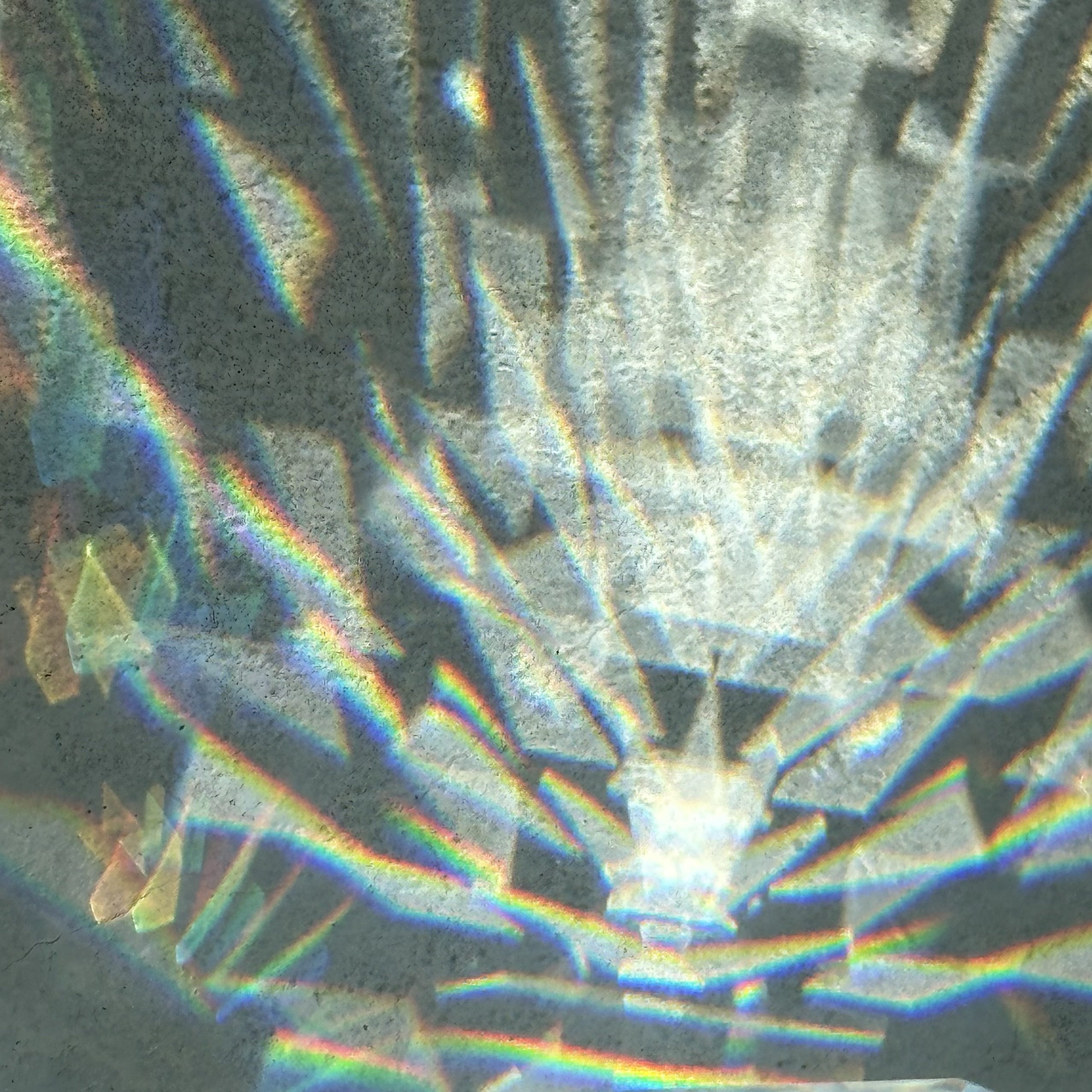 A dazzling array of triangles capture light and shatter it into rainbows and colors giving a physicality to color. iPhone no edits.