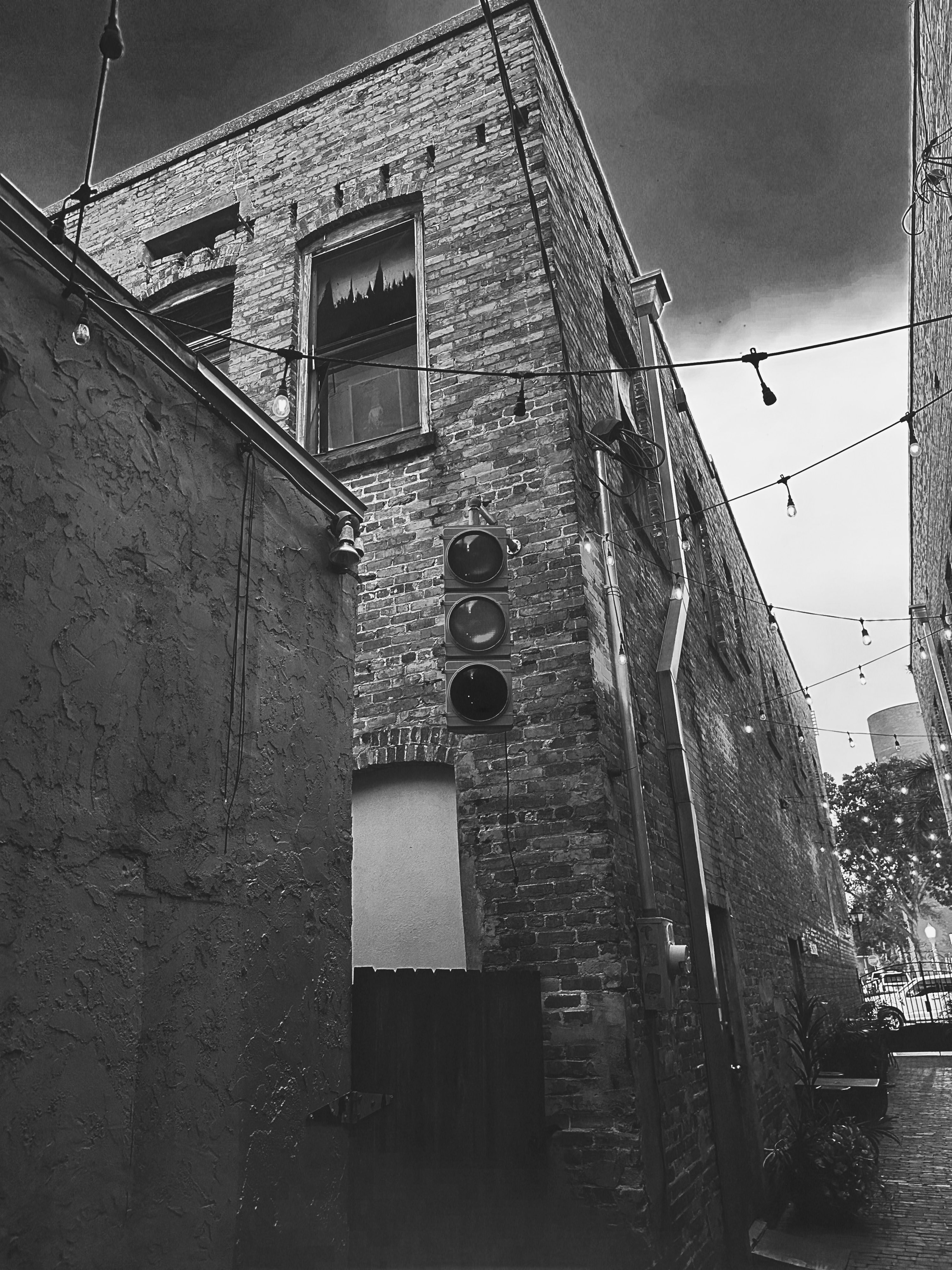 The window upper corner brick building black and white.
